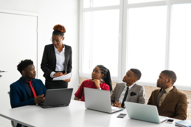 African professionals collaborating around a laptop